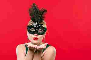 Foto grátis mulher de máscara de carnaval preto mandando beijo