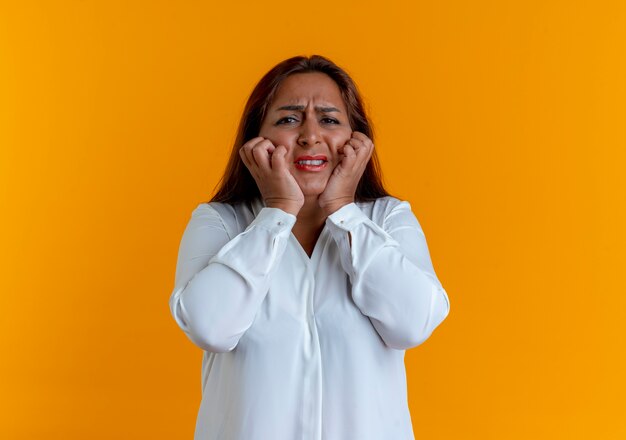 Mulher de meia-idade, caucasiana, preocupada e casual agarrando as bochechas