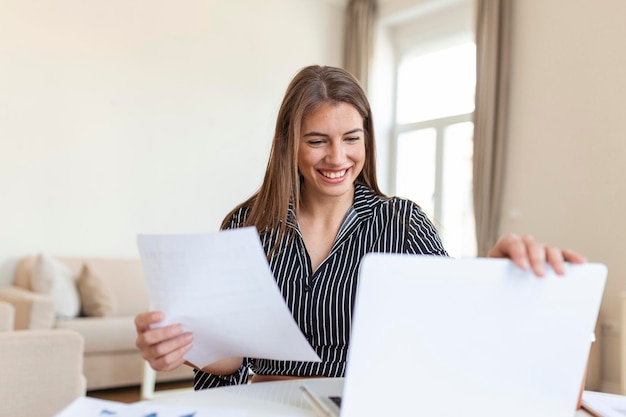 Mulher de negócios analisando dados usando o computador enquanto passa o tempo no escritório Linda jovem sorridente profissional no escritório Gráficos e gráficos