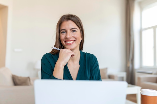 Mulher de negócios analisando dados usando o computador enquanto passa o tempo no escritório Linda jovem sorridente profissional no escritório Gráficos e gráficos