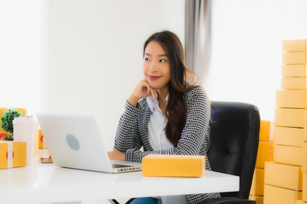 Mulher de negócios asiáticos jovens trabalhando em casa com laptop