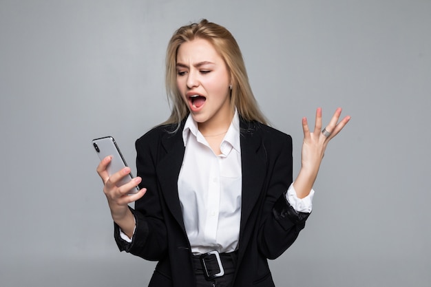 Mulher de negócios bonita surpreendida que conversa pelo telefone que está isolado.