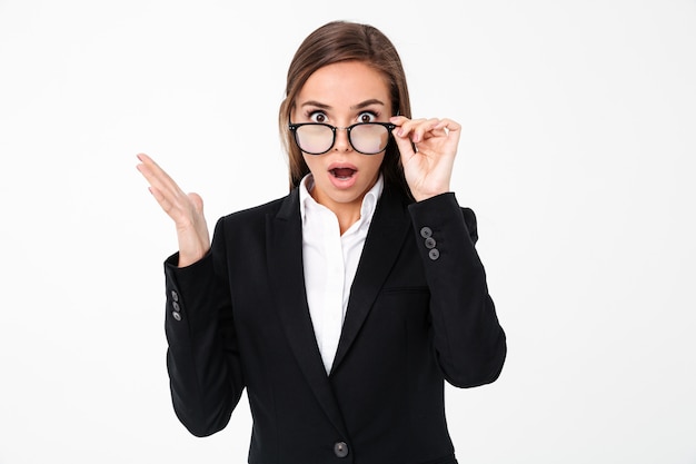 Mulher de negócios chocado usando óculos em pé isolado