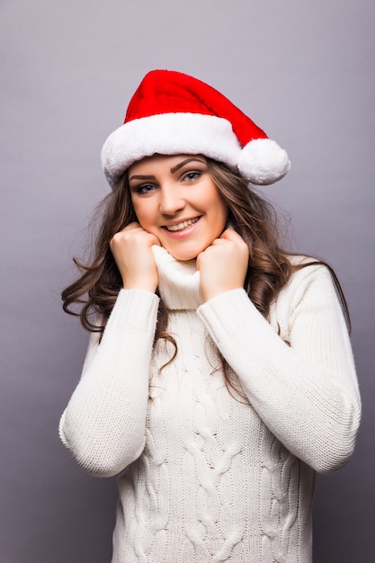 Mulher de negócios com chapéu de Papai Noel vermelho. Retrato isolado de menina santa sorridente.