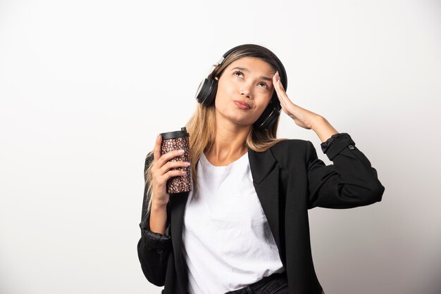 Mulher de negócios com copo e fones de ouvido.