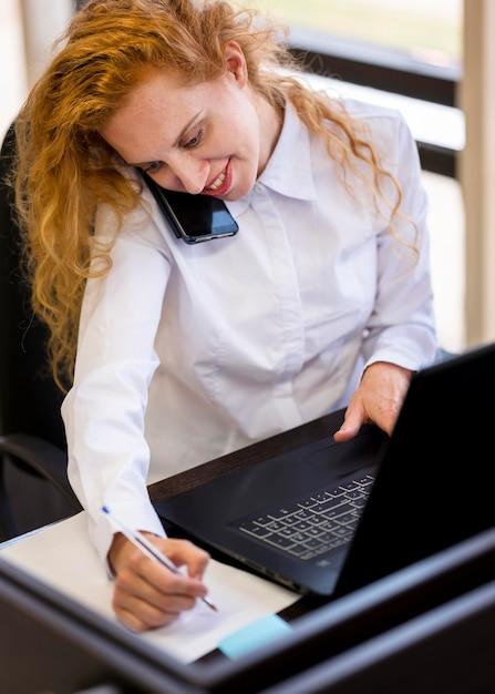 Mulher de negócios de alta vista fazendo atividades multitarefa