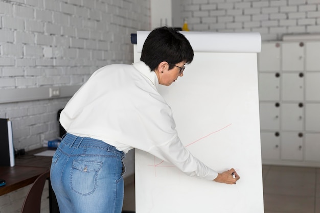 Mulher de negócios de cabelo curto desenhando um gráfico