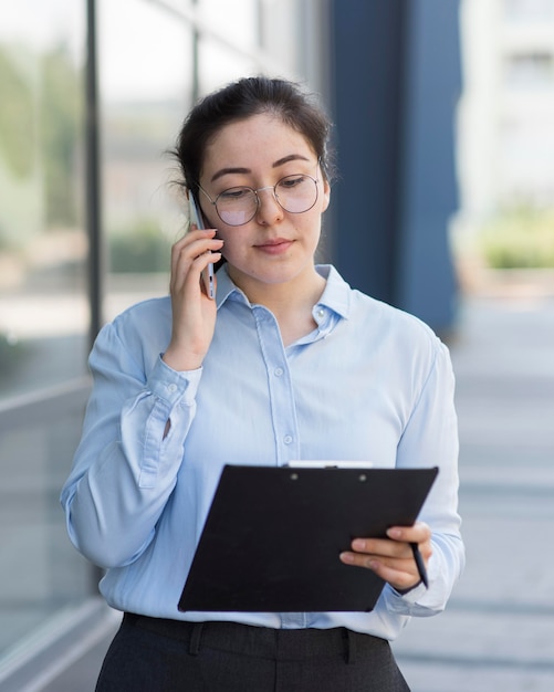 Mulher de negócios de tiro médio usando óculos