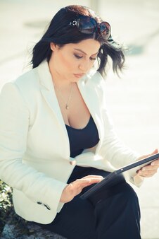 Mulher de negócios elegante lindo cabelo preto longo usando tablet