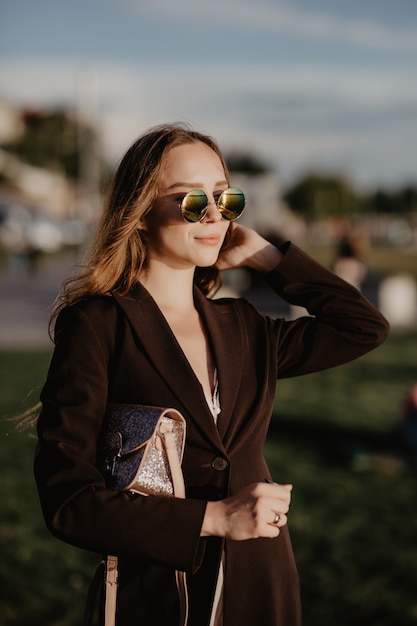 Mulher de negócios elegante usando óculos escuros em um dia quente de verão na cidade