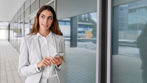 Mulher de negócios elegante usando smartphone ao ar livre com espaço de cópia