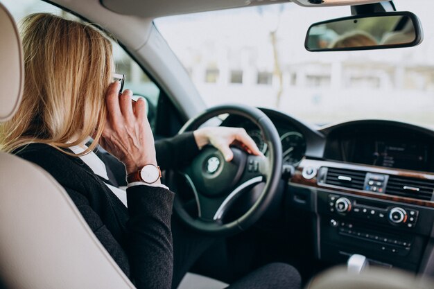 Mulher de negócios em máscara de proteção, sentado dentro de um carro