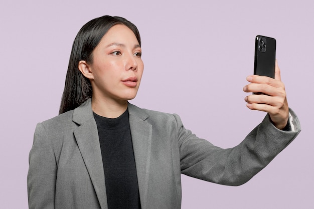 Mulher de negócios examinando o rosto para desbloquear a tecnologia de segurança do telefone