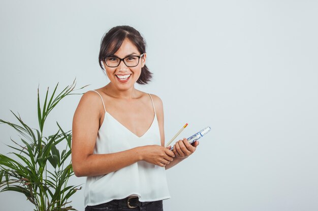 Mulher de negócios feliz com diário, lápis e planta