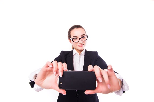 Mulher de negócios feliz tirando foto de selfie em smartphone na parede branca