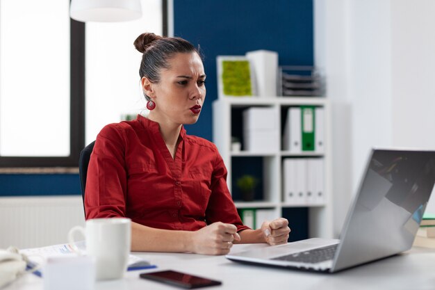 Mulher de negócios frustrada tendo problemas com o laptop não funcionando