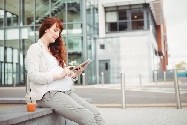 Mulher de negócios grávida usando tablet digital