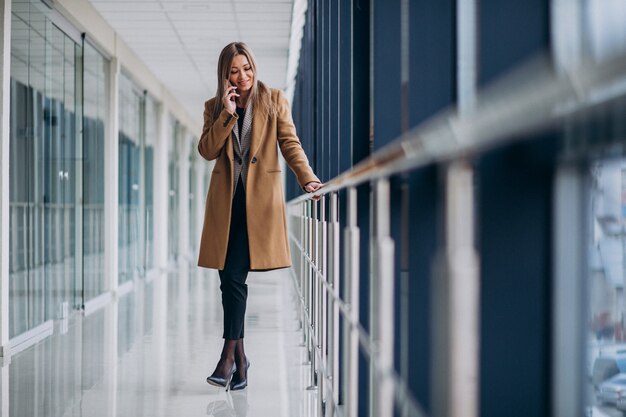 Mulher de negócios jovem falando ao telefone no aeroporto