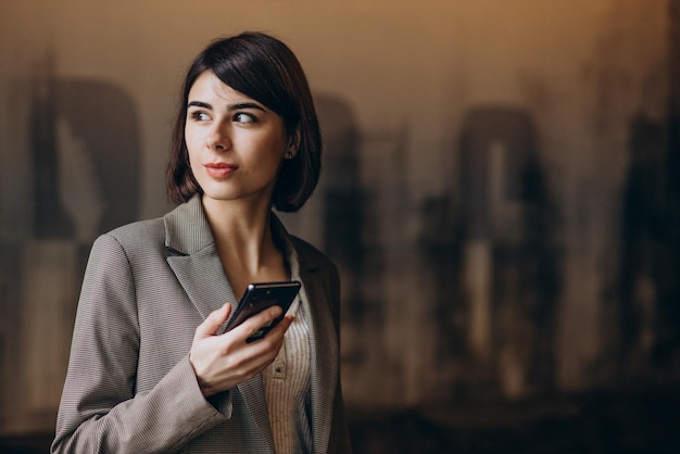 Foto grátis mulher de negócios jovem usando telefone em um café