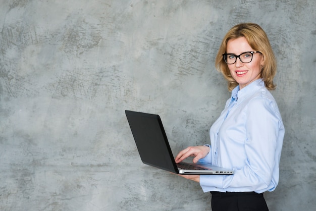 Mulher de negócios loiro usando laptop