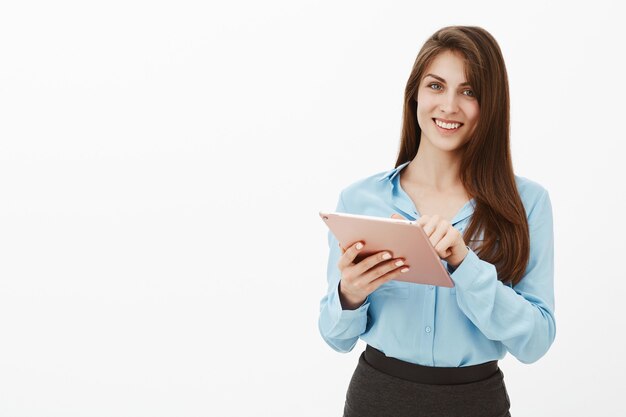 Mulher de negócios morena educada e simpática posando no estúdio