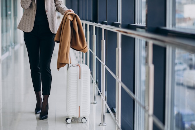 Mulher de negócios no terminal com mala de viagem