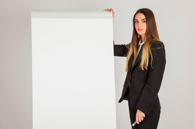 Mulher de negócios que levanta com quadro branco