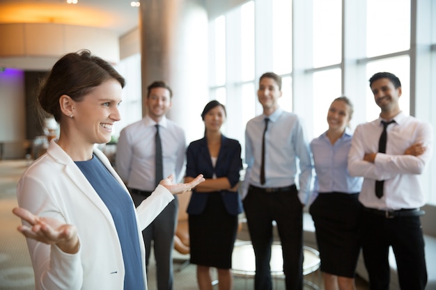 Mulher de negócios que sorri com a equipe