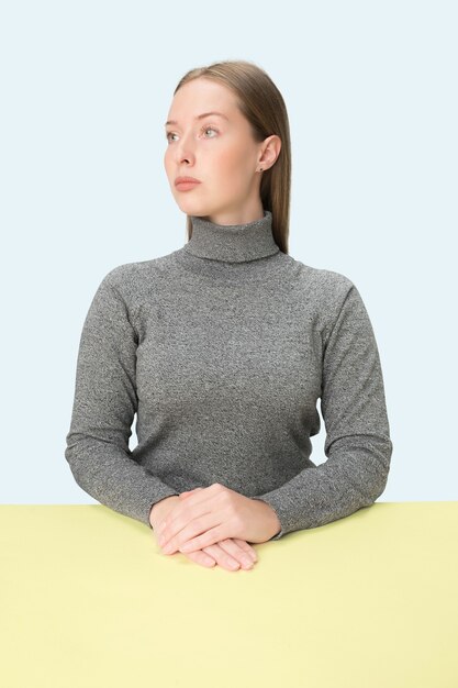 Mulher de negócios sérios sentada à mesa O retrato em estilo minimalista