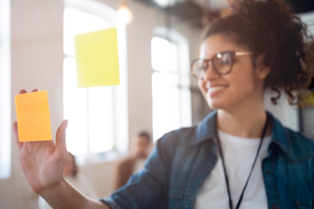 Foto grátis mulher de negócios sorridente de tiro médio com post-its