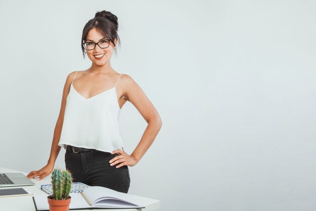 Mulher de negócios sorridente posando com sua mesa