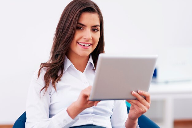 Mulher de negócios sorridente usando um tablet digital