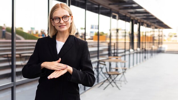 Mulher de negócios usando linguagem de sinais ao ar livre no trabalho