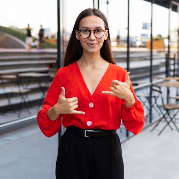 Mulher de negócios usando linguagem de sinais ao ar livre no trabalho