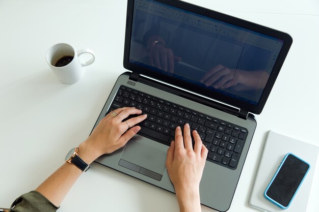 Mulher de negócios usando seu laptop no escritório.