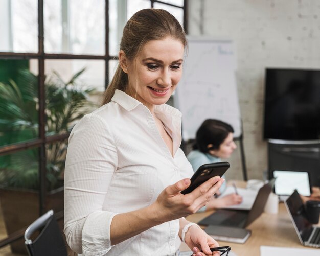 Mulher de negócios usando smartphone durante uma reunião