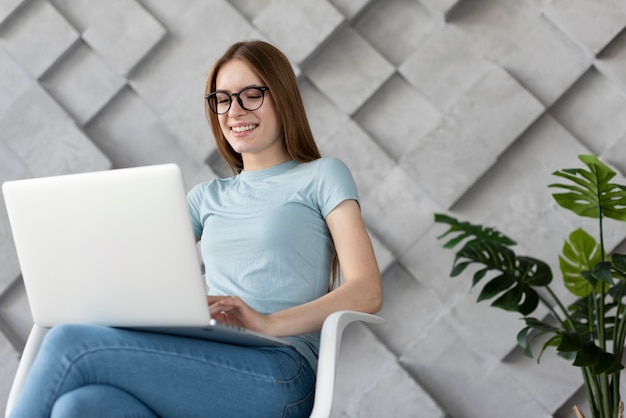 Foto grátis mulher de óculos, olhando através de seu laptop