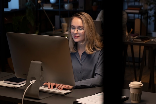 Mulher de óculos usando o computador