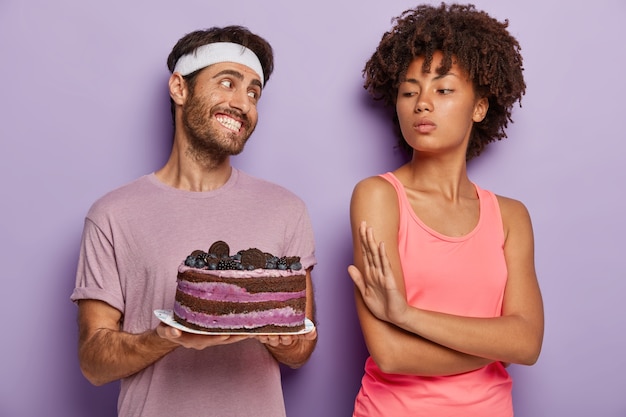 Mulher de pele escura com energia se recusa a comer bolo delicioso no prato