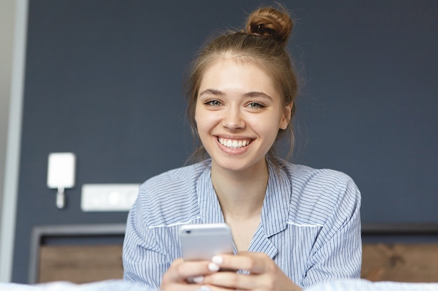 Mulher de pijama segurando smartphone