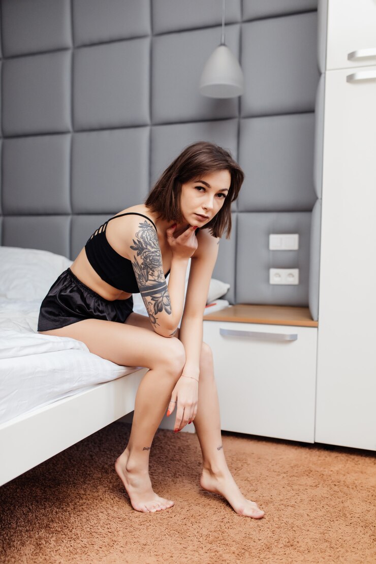 Foto grátis mulher de pijama sexy, sentar na beira da cama em seu quarto brilhante