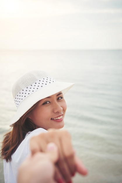 Foto grátis mulher de praia segurando a mão feliz