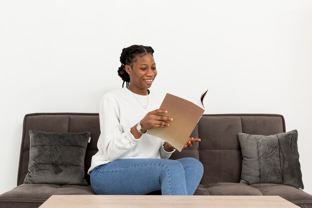 Mulher de retrato no sofá com o livro