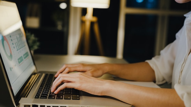 Mulher de Ásia freelance usando laptop trabalho duro na sala de estar em casa.