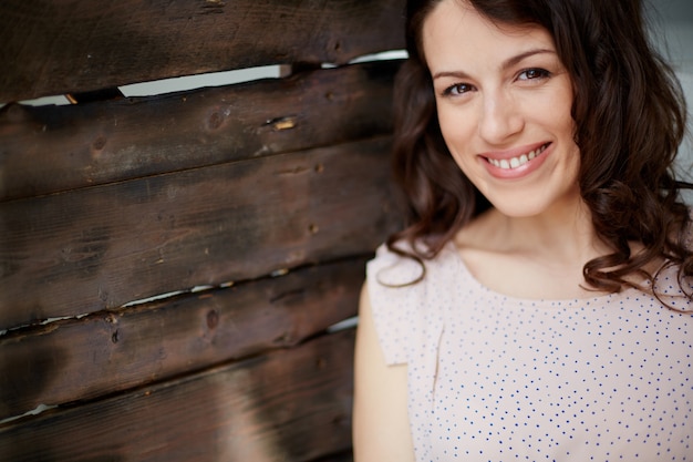Foto grátis mulher de sorriso com fundo de madeira