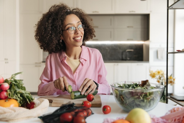 Mulher de sorriso negro cozinhando na cozinha