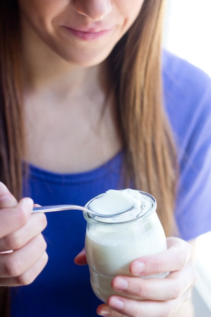Foto grátis mulher de sorriso que come o iogurte