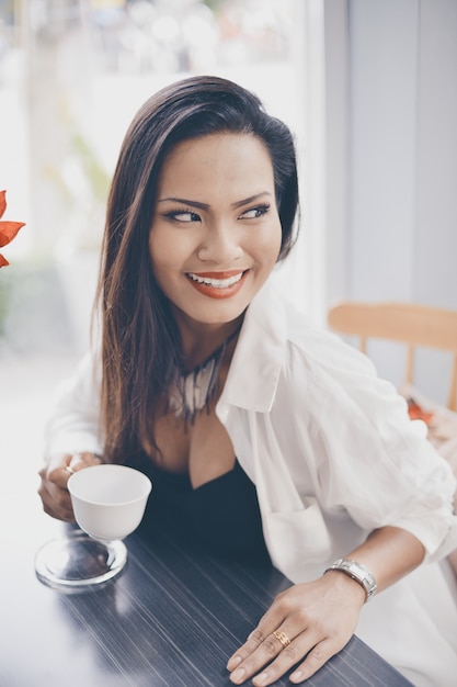 Foto grátis mulher de sorriso que tem uma chávena de café