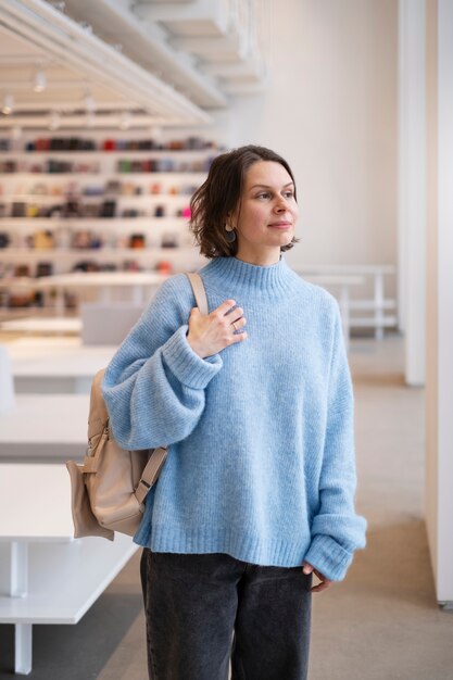 Foto grátis mulher de suéter azul segurando bolsa dentro de casa