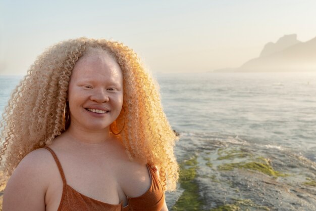 Mulher de tamanho médio posando à beira-mar